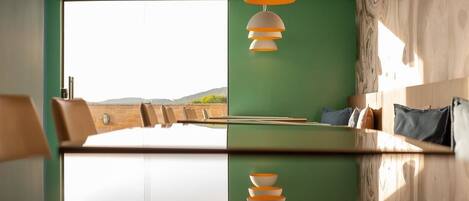 A modern dining area with a large table, chairs, and a view of the outdoors.