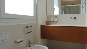 A modern bathroom with a toilet, bidet, and sink. - Appartamento Agamennone (Ragusa)