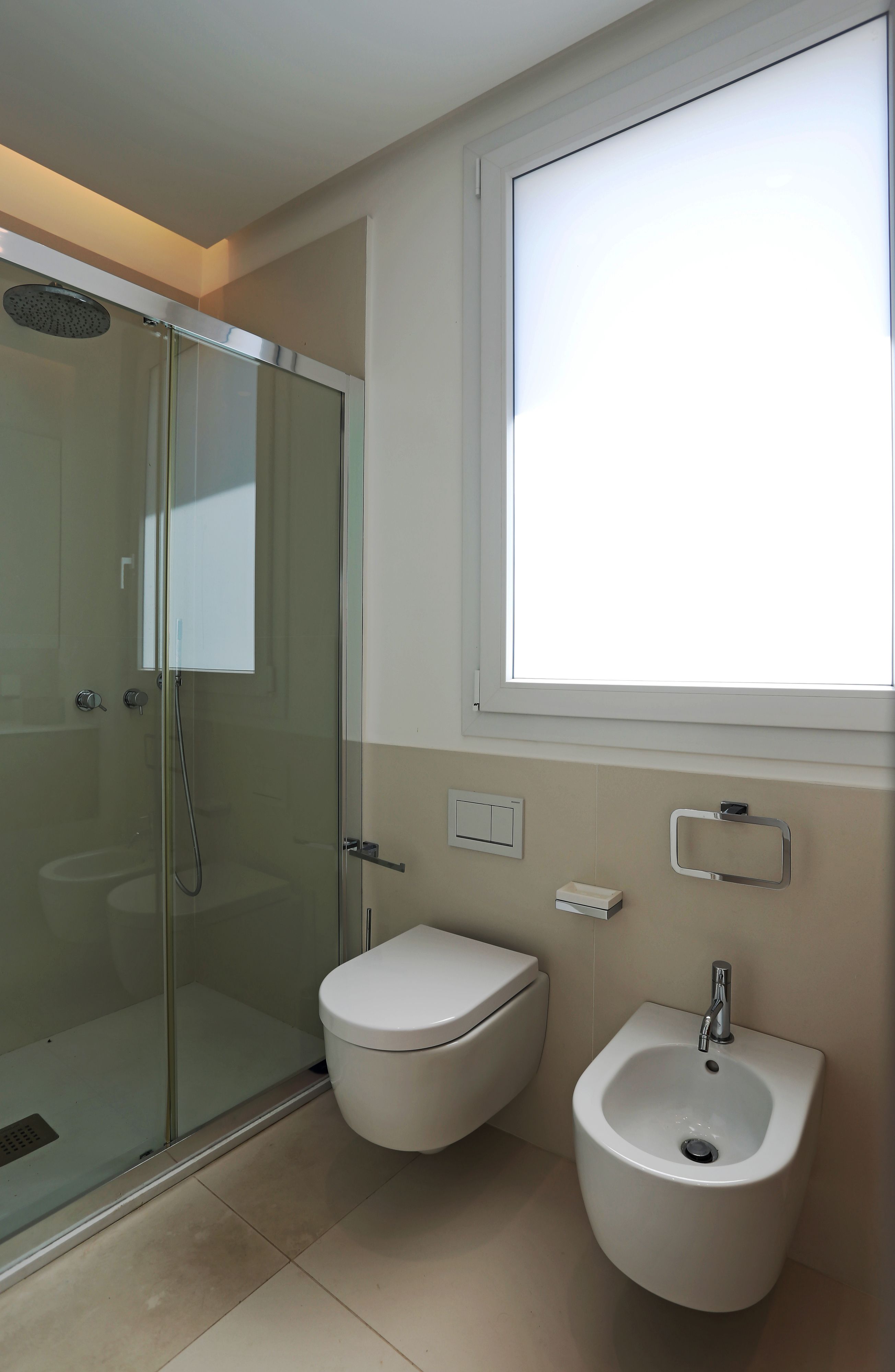 Un baño moderno con ducha acristalada, inodoro y bidé.