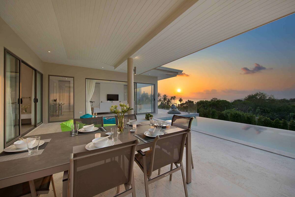 Comedor con una mesa dispuesta para cuatro personas, con vista a un hermoso atardecer.