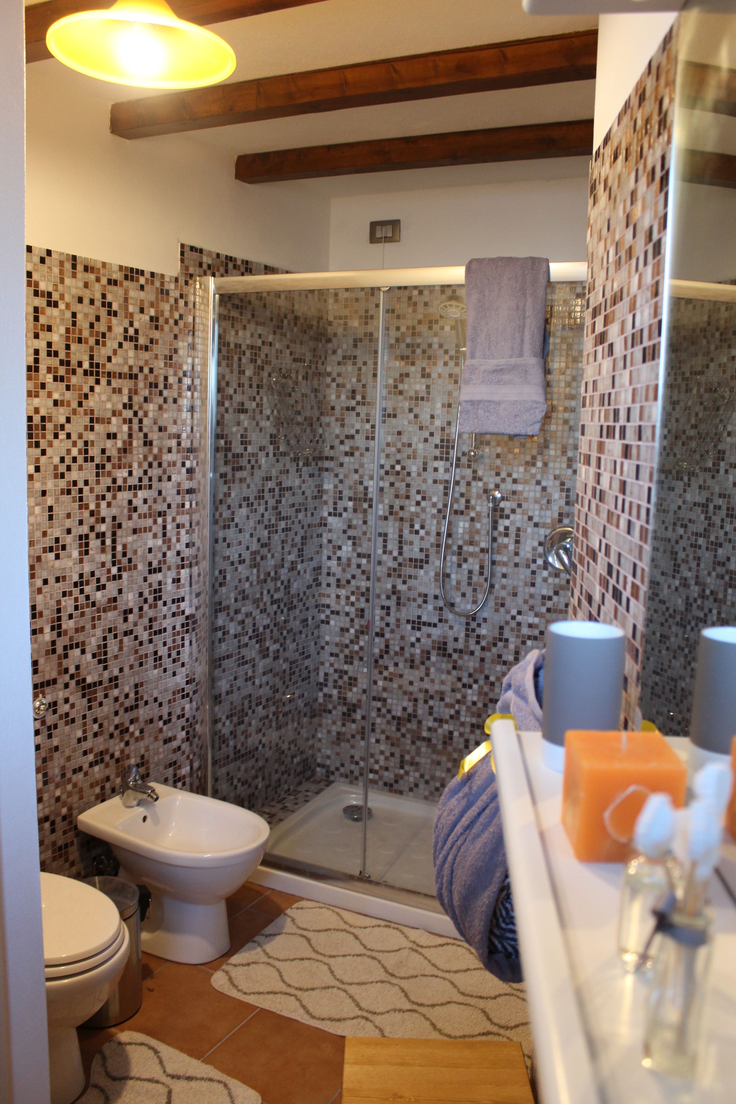 Un bagno con doccia, bidet e lavandino con articoli da toilette.