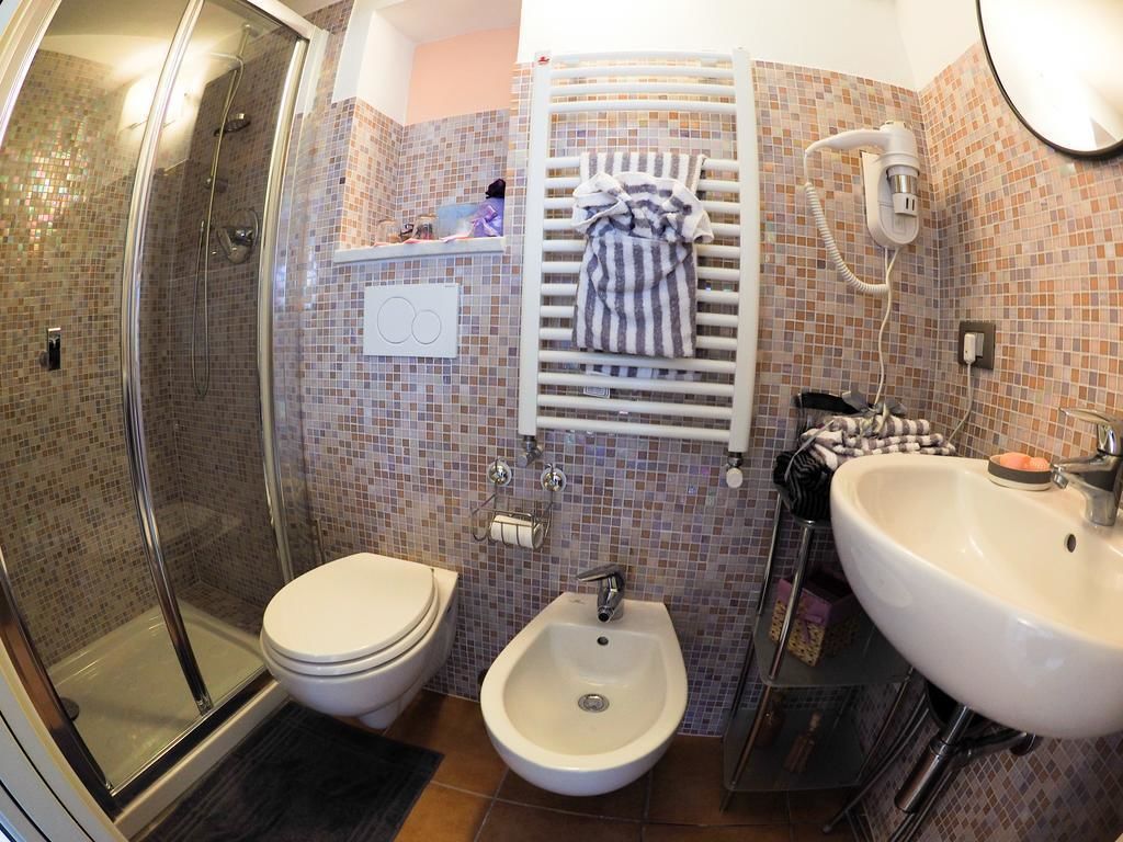 Ein Badezimmer mit Dusche, Toilette, Bidet und Waschbecken.