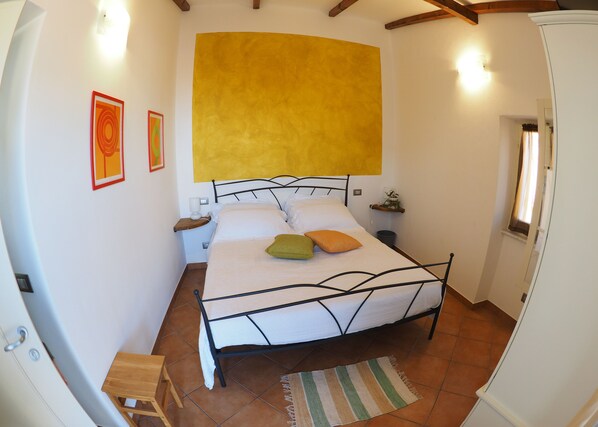 A bedroom with a bed, bedside tables, a nightstand, a window, and a door.