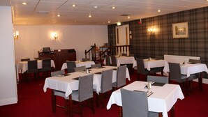 A dining area with multiple tables and chairs, a red carpet, and a staircase leading to an upper level. - Ravenswood Country Club Legion Scotland (Banchory)