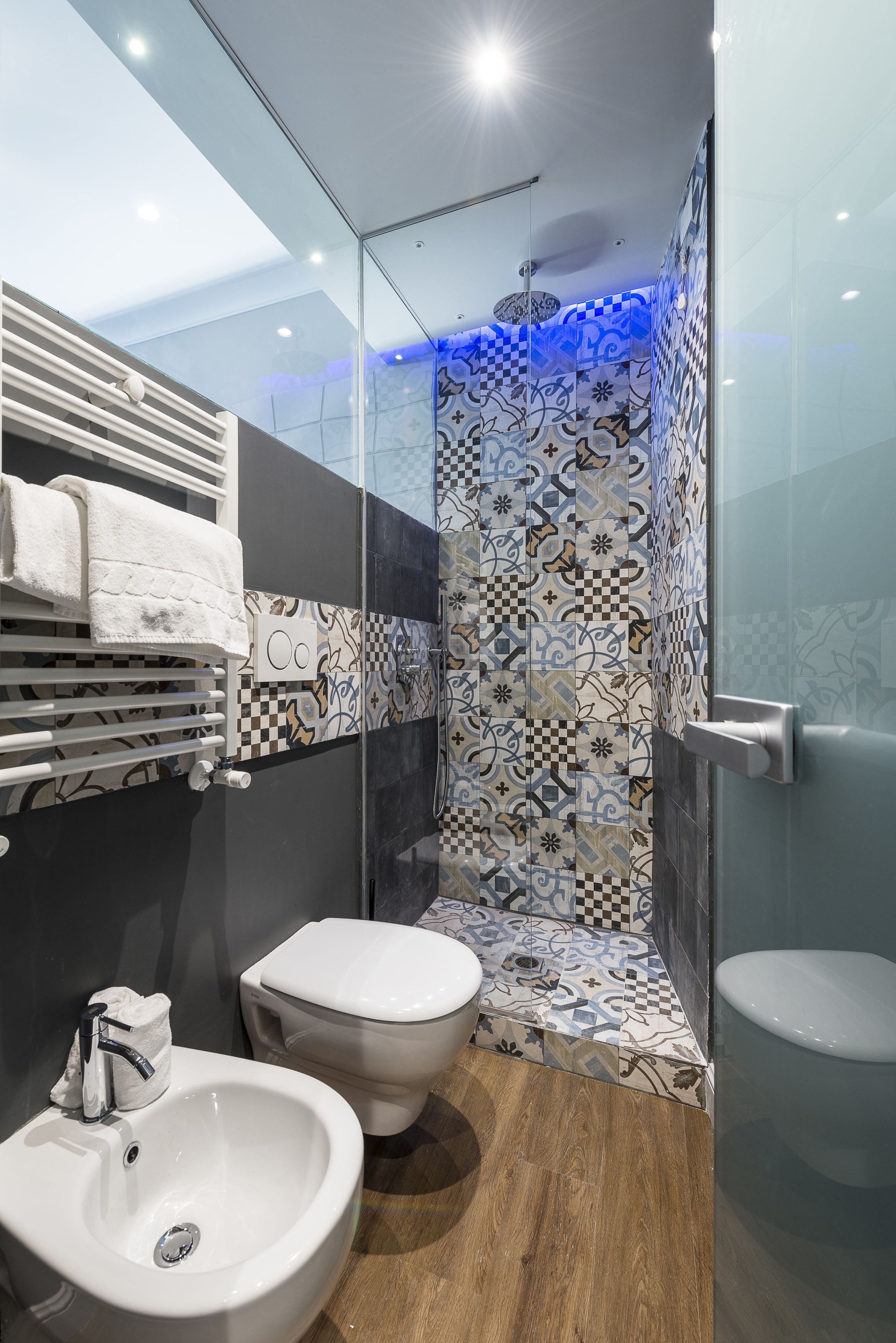 Une salle de bain moderne avec une douche à parois de verre, un lavabo blanc et des toilettes.