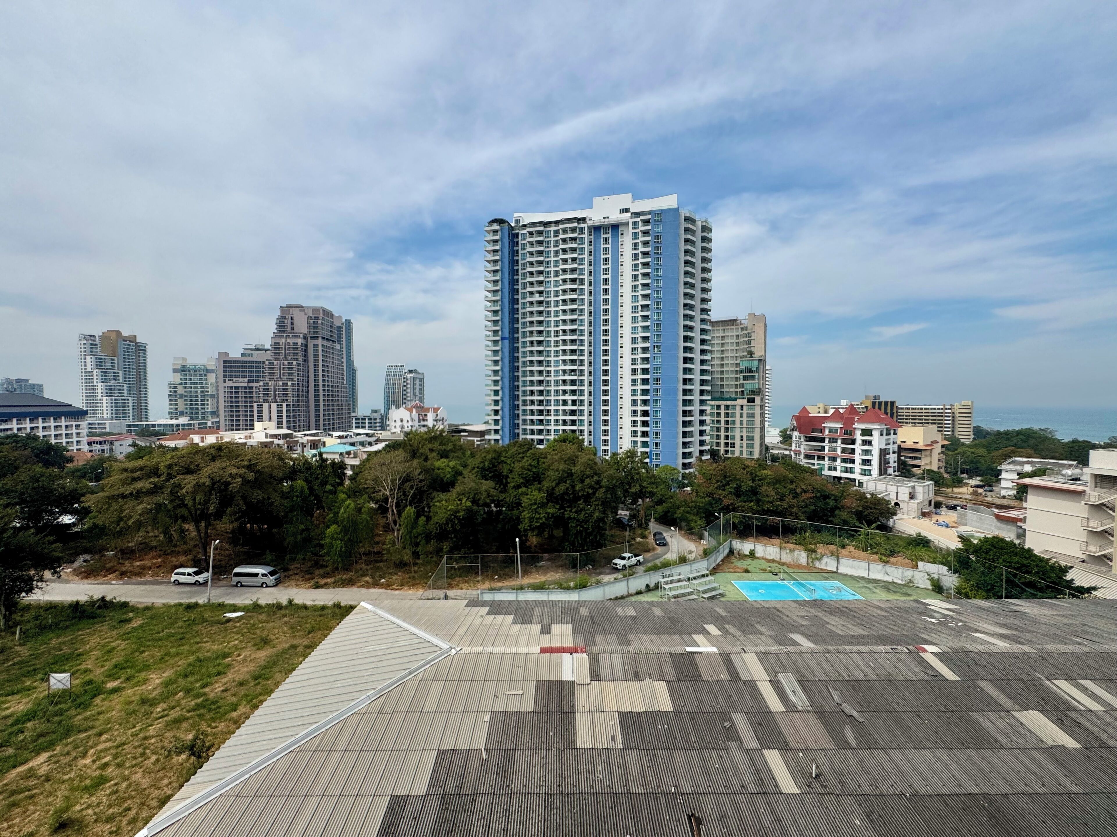 A high-rise building with a modern design, surrounded by other high-rise buildings and greenery.