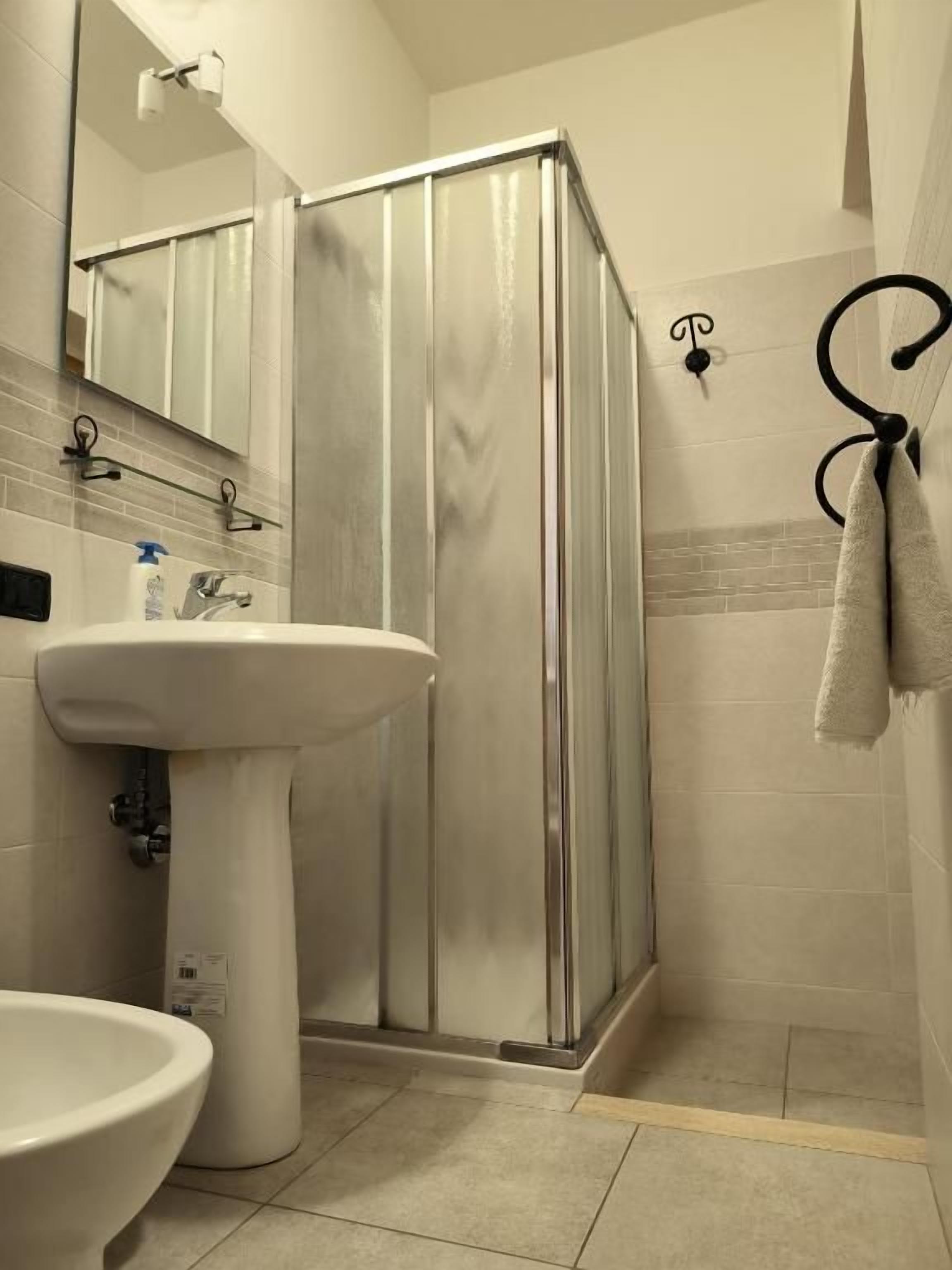 Un bagno con doccia, lavandino e WC.
