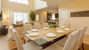 A dining area with a glass-top table set for six, surrounded by six chairs.