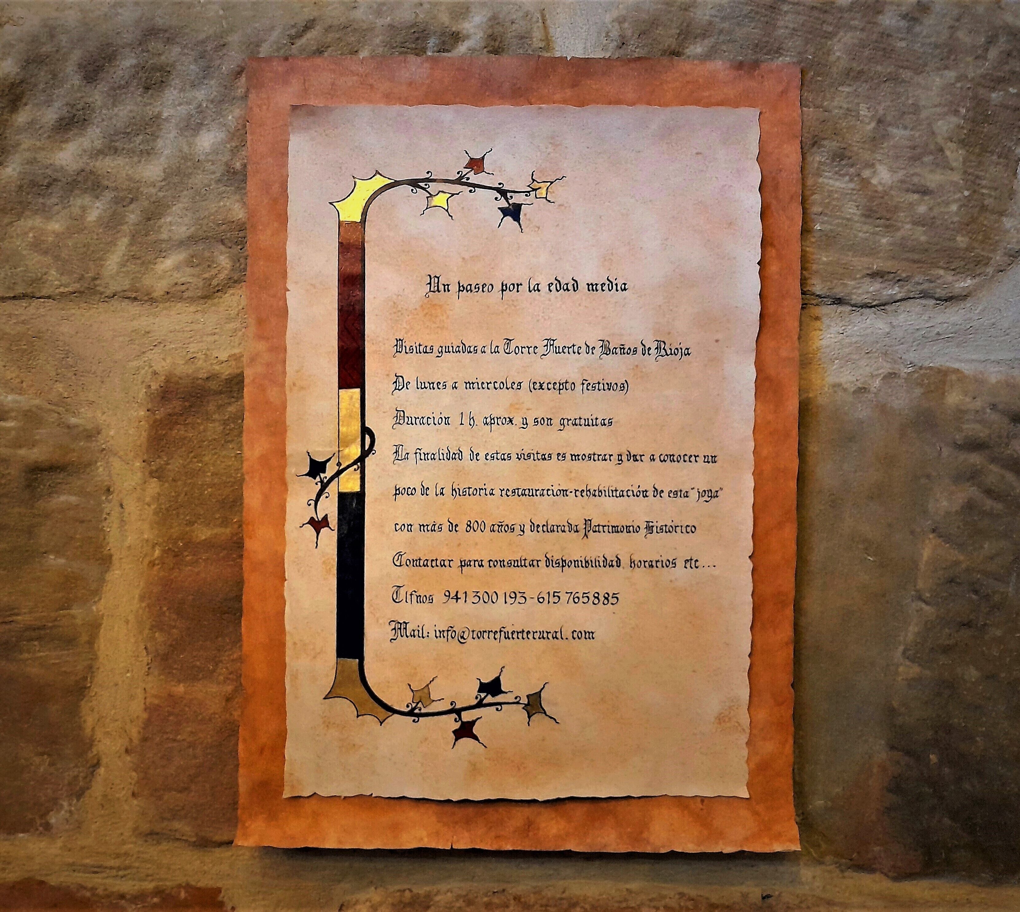 A historical plaque with text about guided tours at the Torre de los Huesos de Rioja, including contact information.