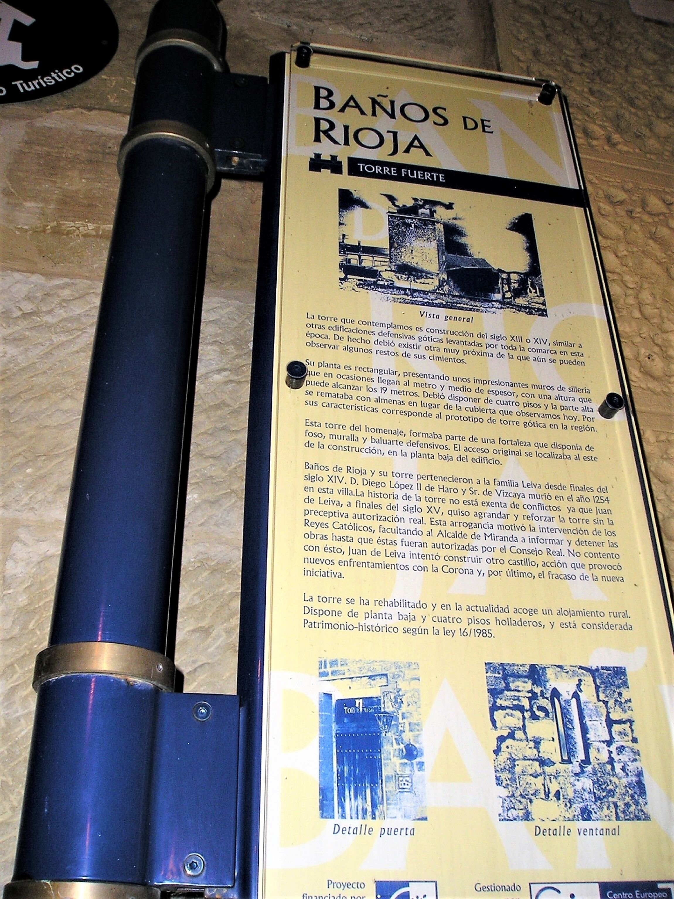 Una torre històrica amb una placa que detalla la seva història i construcció.