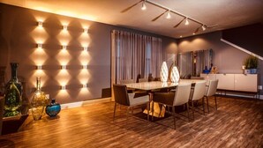 A modern dining area with a wooden floor, a long table, and several chairs. - Aco259112 - The Encore Club Resort - 8 Bed 8 Baths Villa (Kissimmee)