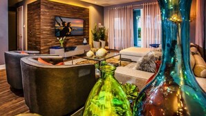 A modern living room with a flat-screen TV, comfortable seating, and decorative vases. - Aco259112 - The Encore Club Resort - 8 Bed 8 Baths Villa (Kissimmee)
