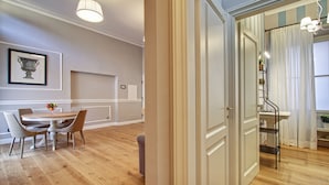 A dining area with a round table and four chairs, a framed artwork on the wall, and a wooden floor. - Art Apartment Campidoglio (Florence)