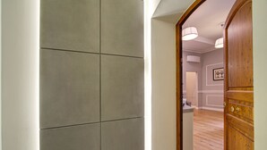 A hallway with a wooden door and a light fixture. - Art Apartment Campidoglio (Florence)