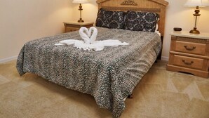 A neatly made bed with a leopard print bedspread, two bedside lamps, and a headboard with a carved design. - Ahr86 - Sunset Ridge - 5 Bed 4 Baths Villa (Davenport)