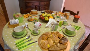 A dining table set with various food items, utensils, and tableware. - La Loggetta (Bagnoregio)