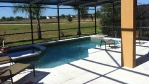 An outdoor pool area with a glass enclosure, a hot tub, and lounge chairs. - Ip60471 - The Shire at West Haven - 5 Bed 3 Baths Villa (Davenport)