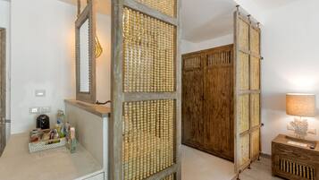 Una habitación con un armario de madera, un espejo y una pared con textura tejida.
