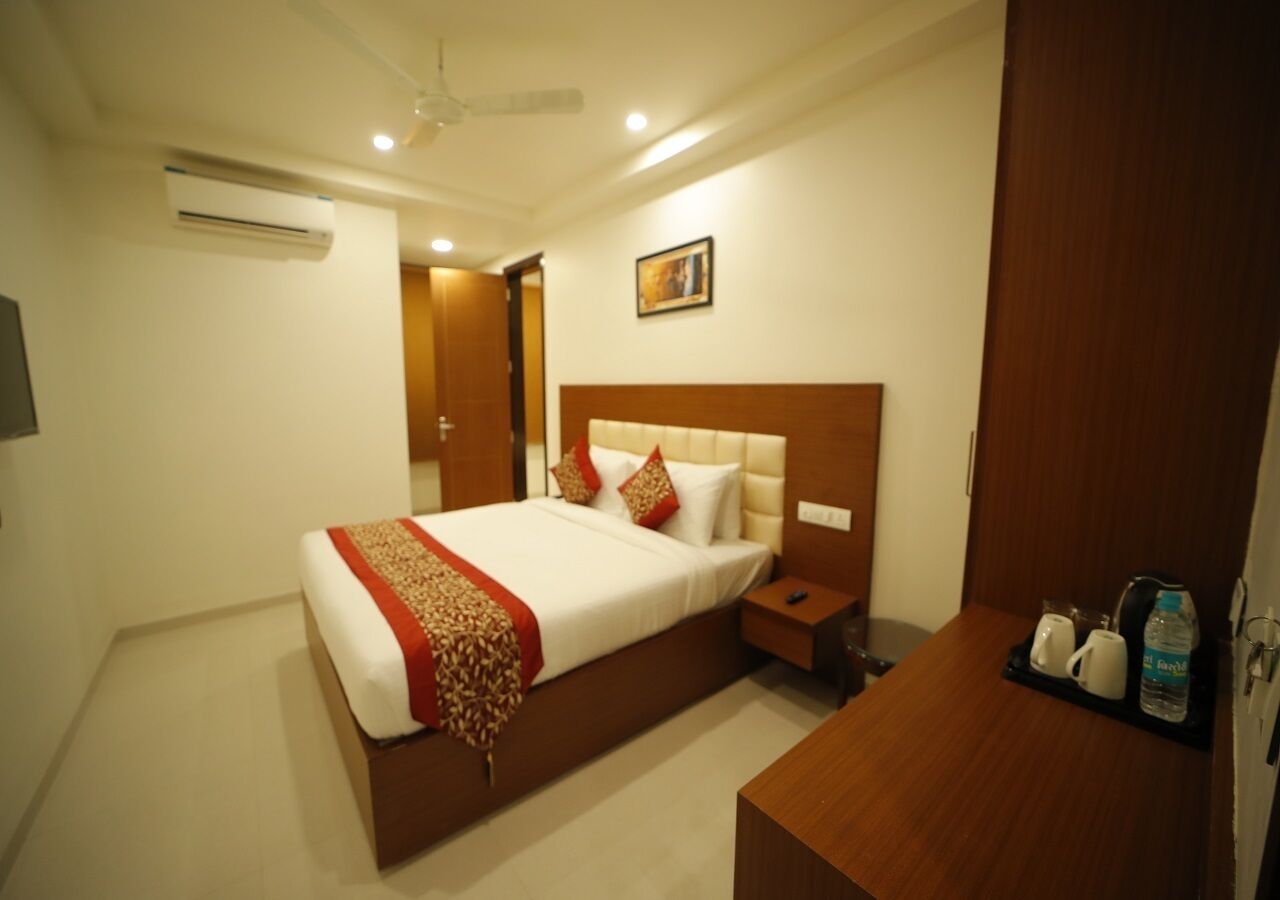 Una habitación de hotel con cama, mesita de noche y velador.