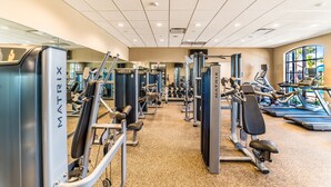 Ein Fitnessstudio mit verschiedenen Trainingsgeräten, Laufbändern und Gewichten.