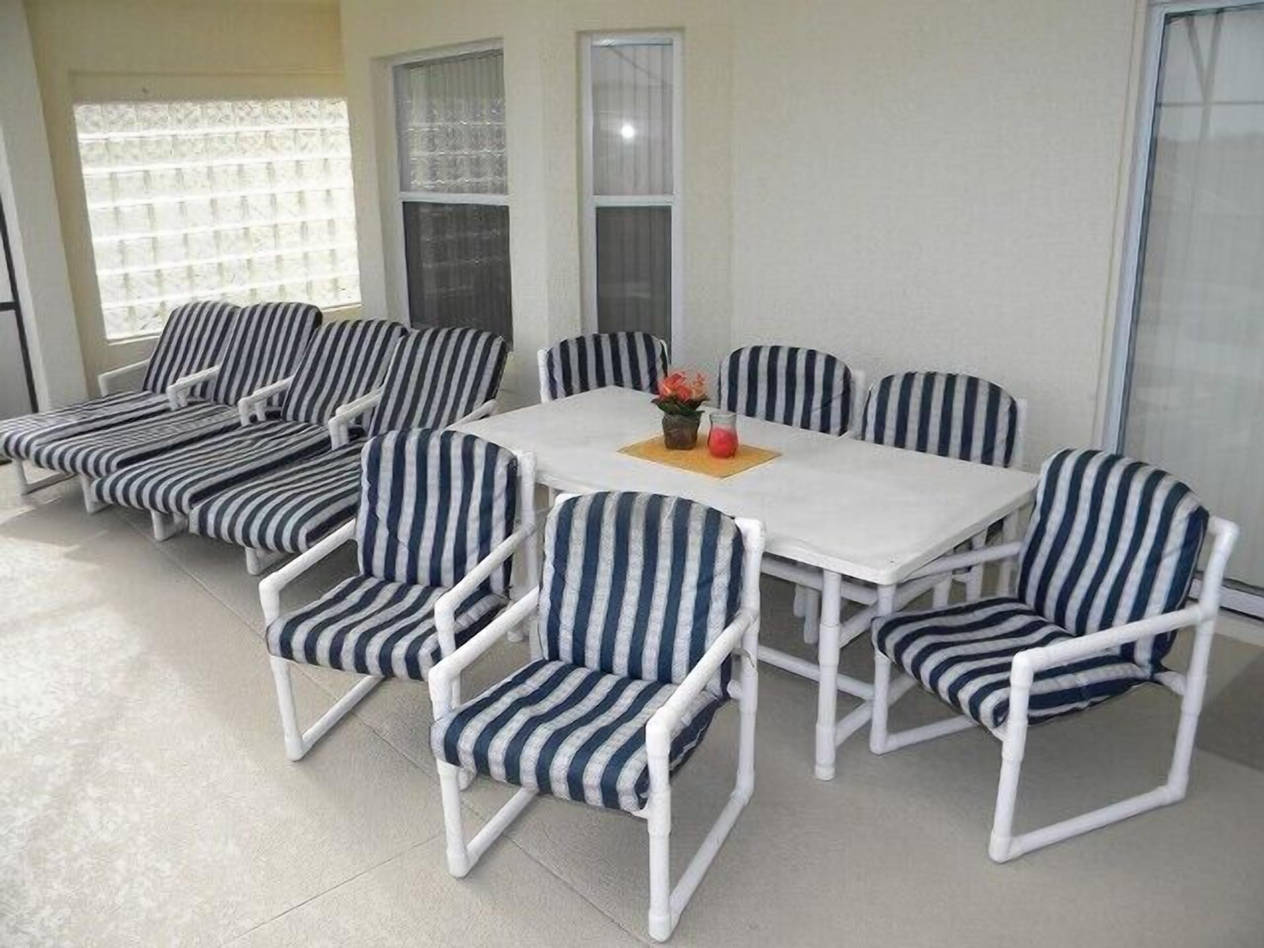 Un coin repas avec une table blanche et des chaises à rayures.