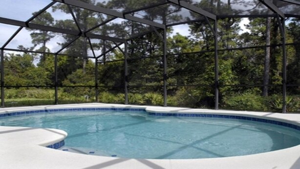 A swimming pool with a clear blue water, surrounded by a metal fence and trees in the background. - Bjw538 - Sandy Ridge - 4 Bed 3 Baths Villa (Davenport)