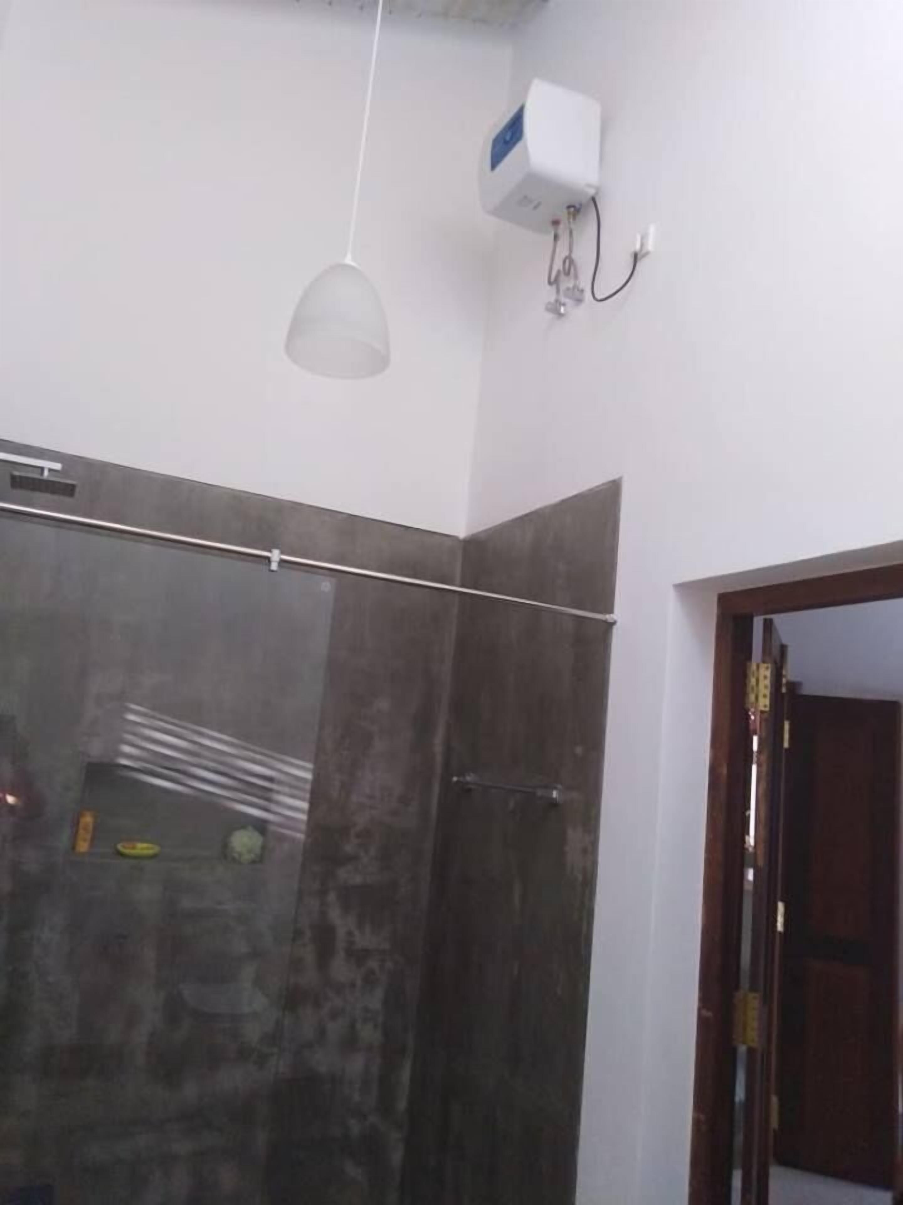 A bathroom with a glass shower enclosure, a towel rack, and a ceiling-mounted light fixture.