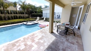 A swimming pool with a tiled deck, a covered patio area with a table and chairs, and a ceiling fan. - Aco231262 - The Encore Club Resort - 6 Bed 5.5 Baths Villa (Kissimmee)