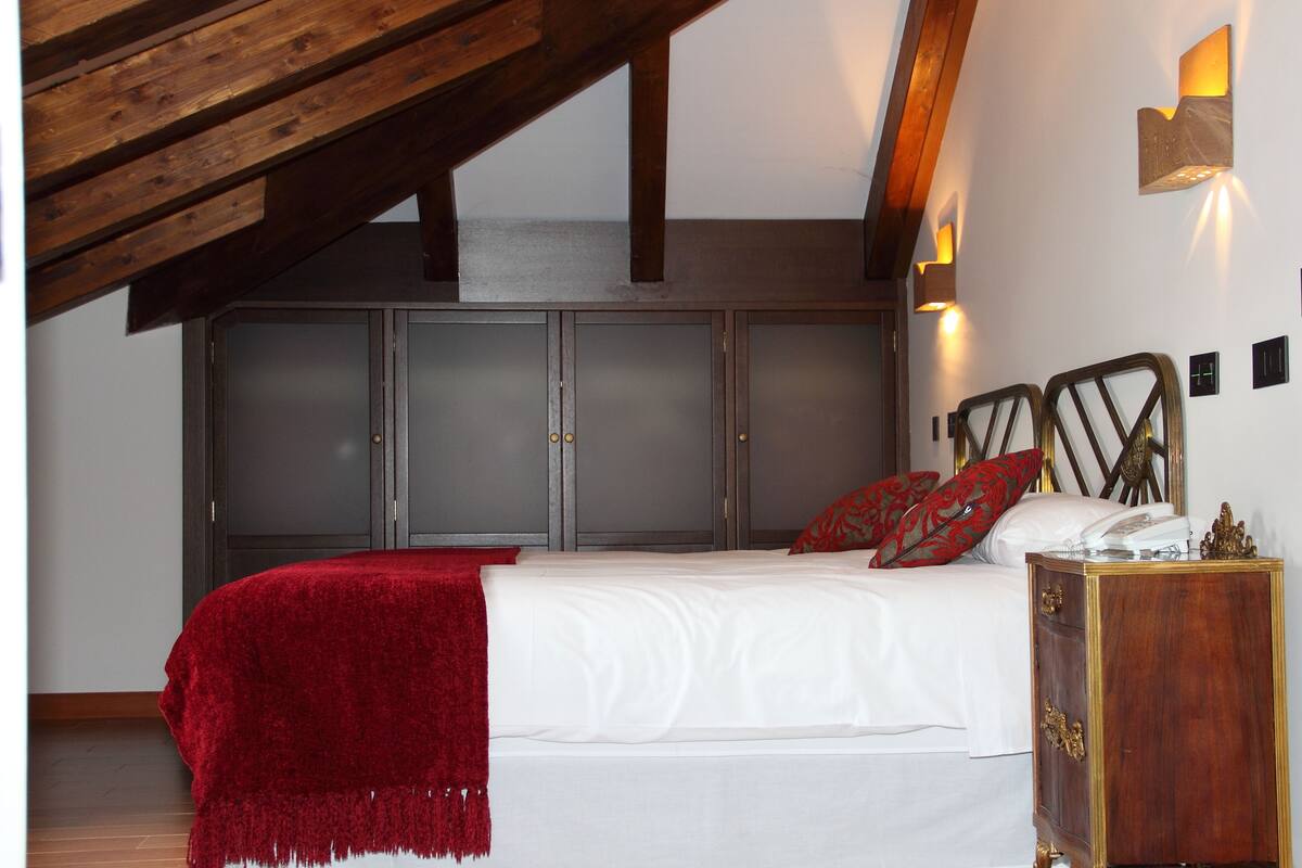 A bedroom with a bed, a nightstand, and a wardrobe.