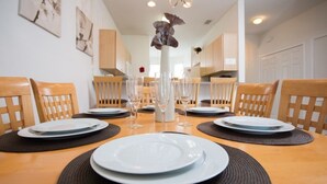 A dining table set for four with plates, glasses, and a vase. - Ip60384 - Fiesta Key - 3 Bed 2.5 Baths Townhome (Kissimmee)