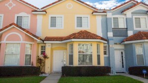A row of three-story townhouses with distinct pastel colors, each featuring a front door and windows. - Ip60384 - Fiesta Key - 3 Bed 2.5 Baths Townhome (Kissimmee)