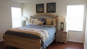A bedroom with a wooden bed, two bedside tables, and a window with blinds. - Aco63671 - Bella Vida Resort - 6 Bed 5.5 Baths Villa (Kissimmee)