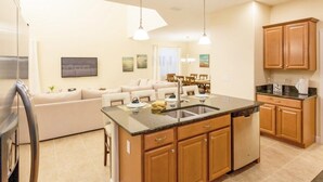 A modern kitchen with wooden cabinets, a central island with a sink, and pendant lighting.
