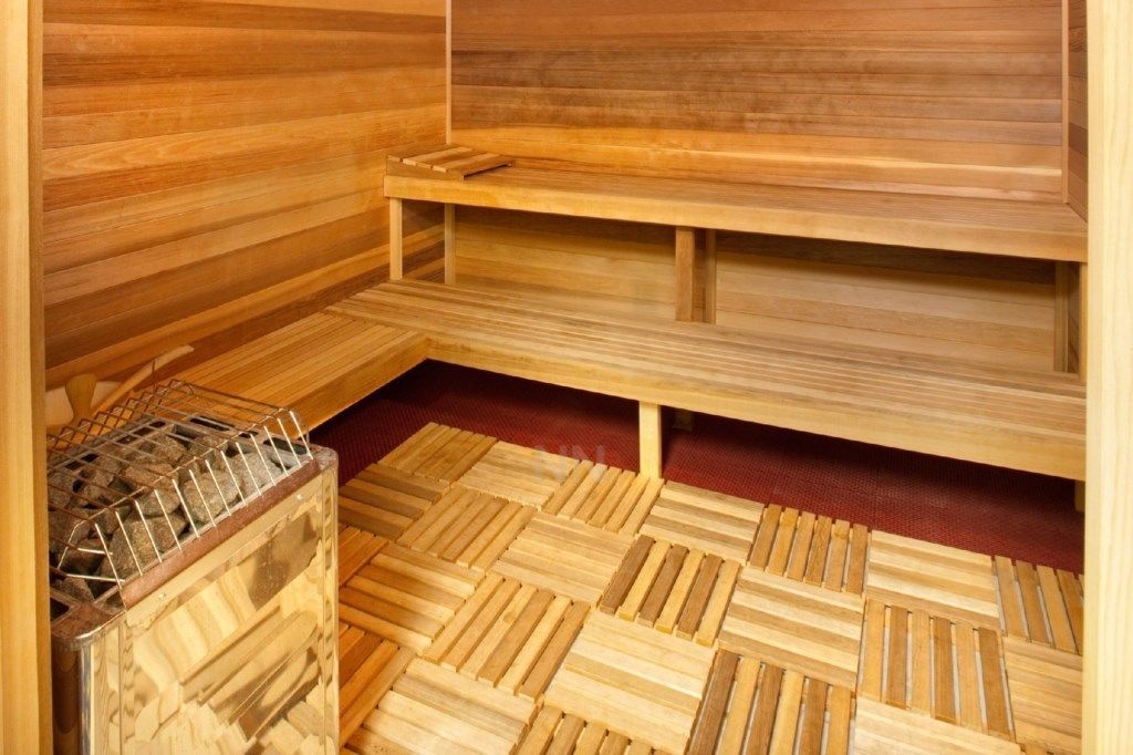 A sauna room with wooden benches and a metal rack for towels.