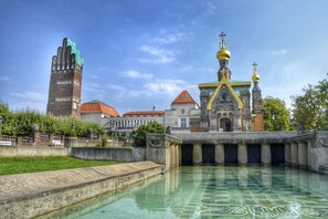 A historic building with a large tower and a pool area in front. - Boutique & Luxury-Apartments Horster (Bensheim)