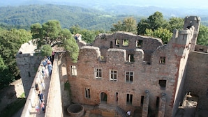 Un antiguo edificio de piedra con un patio central, rodeado por un muro alto y un sendero para visitantes.