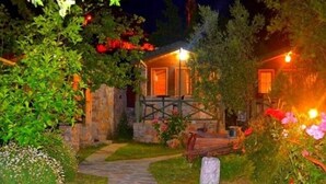 A stone pathway leading to a rustic building with a warm light source. - Montenegro Motel (Fethiye)