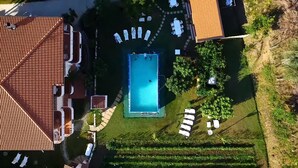 Une piscine rectangulaire située sur le toit, entourée de chaises longues et d’une petite terrasse.