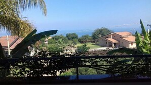 Un quartier résidentiel avec des maisons, un ciel dégagé et une vue sur la mer.