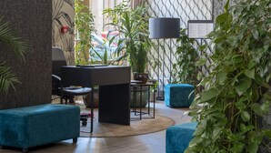 A modern lobby with a desk, seating area, and potted plants. - Hotel Memories Budapest (Budapest)