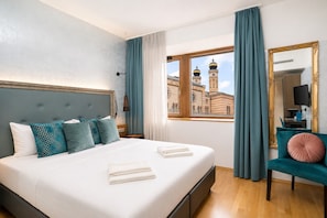A hotel room with a bed, a chair, a large window with a view of a building, and a mirror. - Hotel Memories Budapest (Budapest)