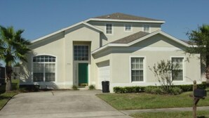 A two-story house with a green door, a garage, and a front yard with a mailbox. - Ahr123 - Hampton Lakes - 5 Bed 3 Baths Villa (Davenport)