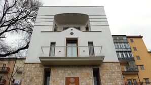 A modern building with a stone facade, a balcony with metal railings, and a sign indicating it is a hotel. - Bora B&B (Troia)