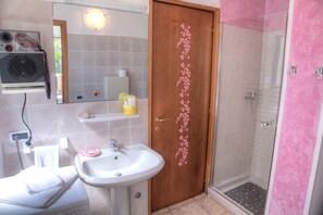 Ein Badezimmer mit Waschbecken, Spiegel und Dusche.