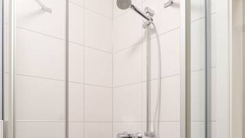 Una ducha moderna con cabezal de ducha manual y llave de control en la pared.