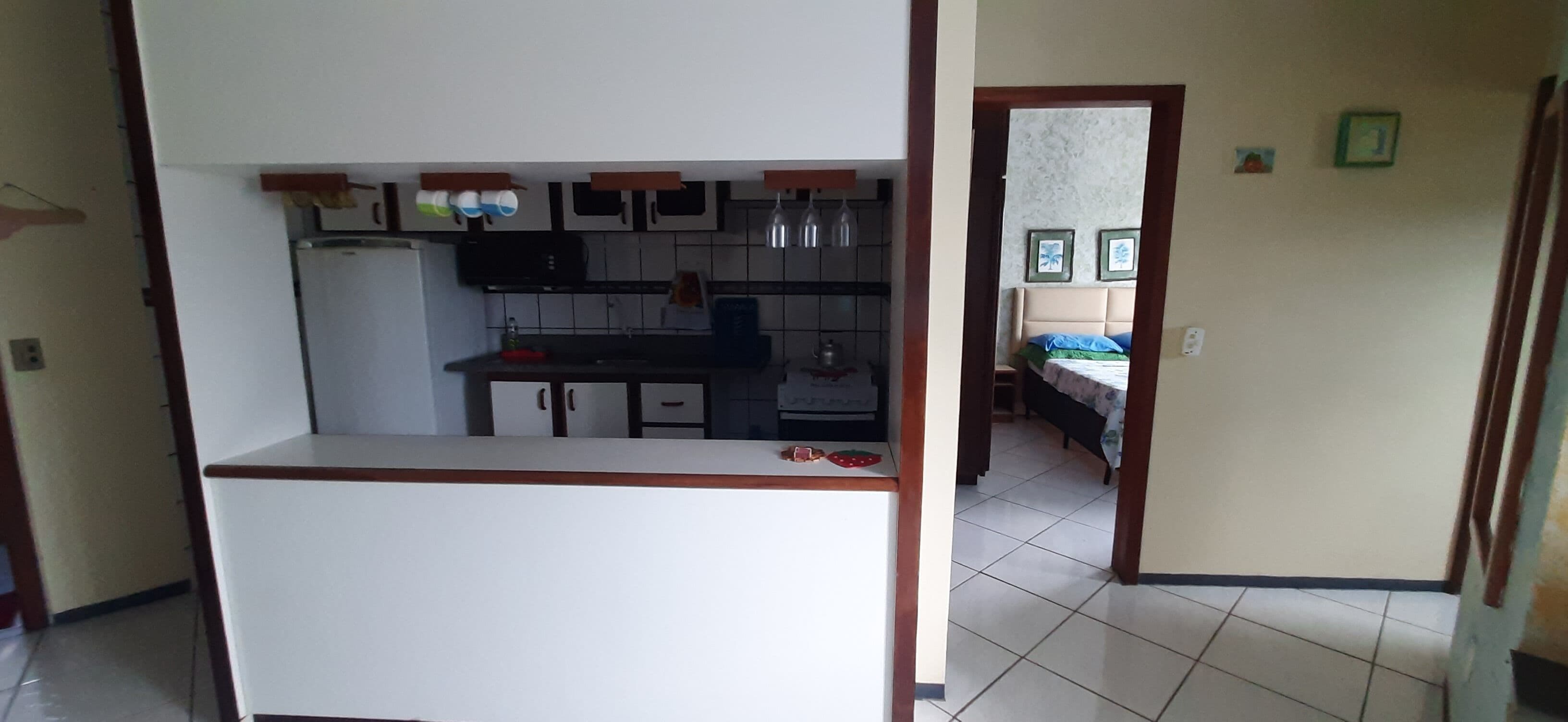 Cozinha compacta com geladeira, fogão e armários.