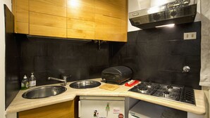 Une cuisine de taille réduite, équipée d’un évier, d’une cuisinière et d’un grille-pain.