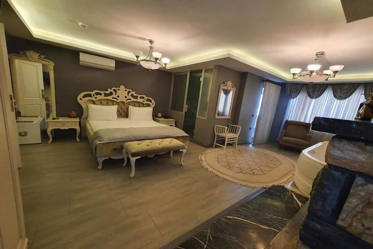 Un dormitorio amplio con una cama grande, una zona de estar y vistas a la ciudad.