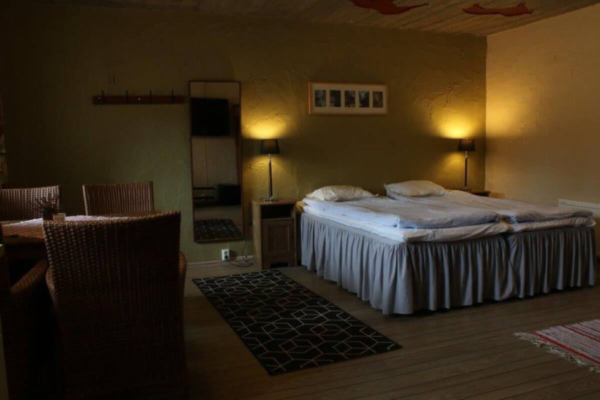Une chambre à coucher avec un lit, deux lampes de chevet, une petite table et une chaise.