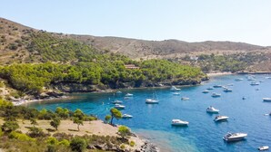 A coastal landscape with boats, a beach, and a building on a hillside. - Stunning seaview apartment 2 terraces barbecue private parking 5m from the beach (Roses)